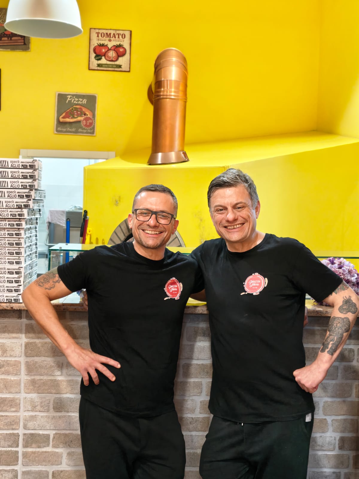 Staff di Piazza Nova Pizzeria davanti al forno a legna a Genzano di Roma